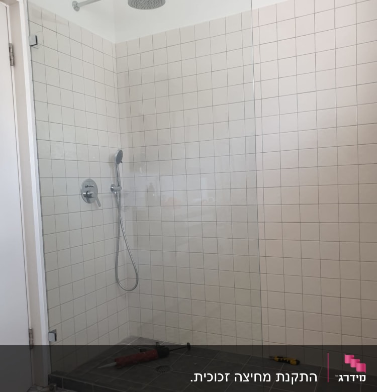 מחיצת זכוכית במקלחת עם ראש מקלחת